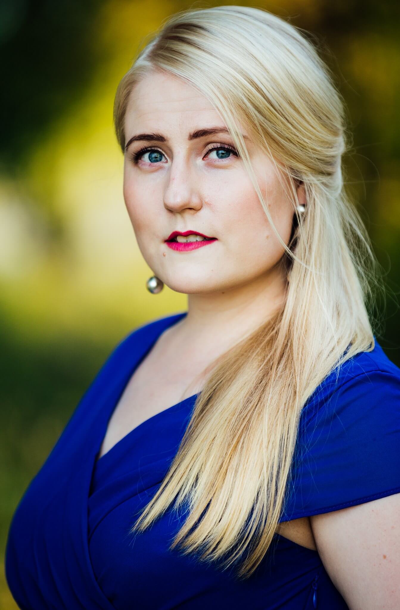 Lyshårede Johanna Nylund med rosafarvede læber og intense smukke øjne foran sløret gullig baggrund