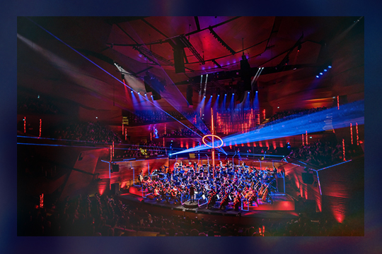 Koncertsalen i Vertigo til koncerten Gaming X Symphony 2024 oplyst i røde og lilla nuancer.
