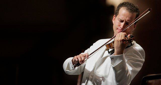 Nikolaj Znaider iført hvidt jakkesæt ifærd med at spille violin