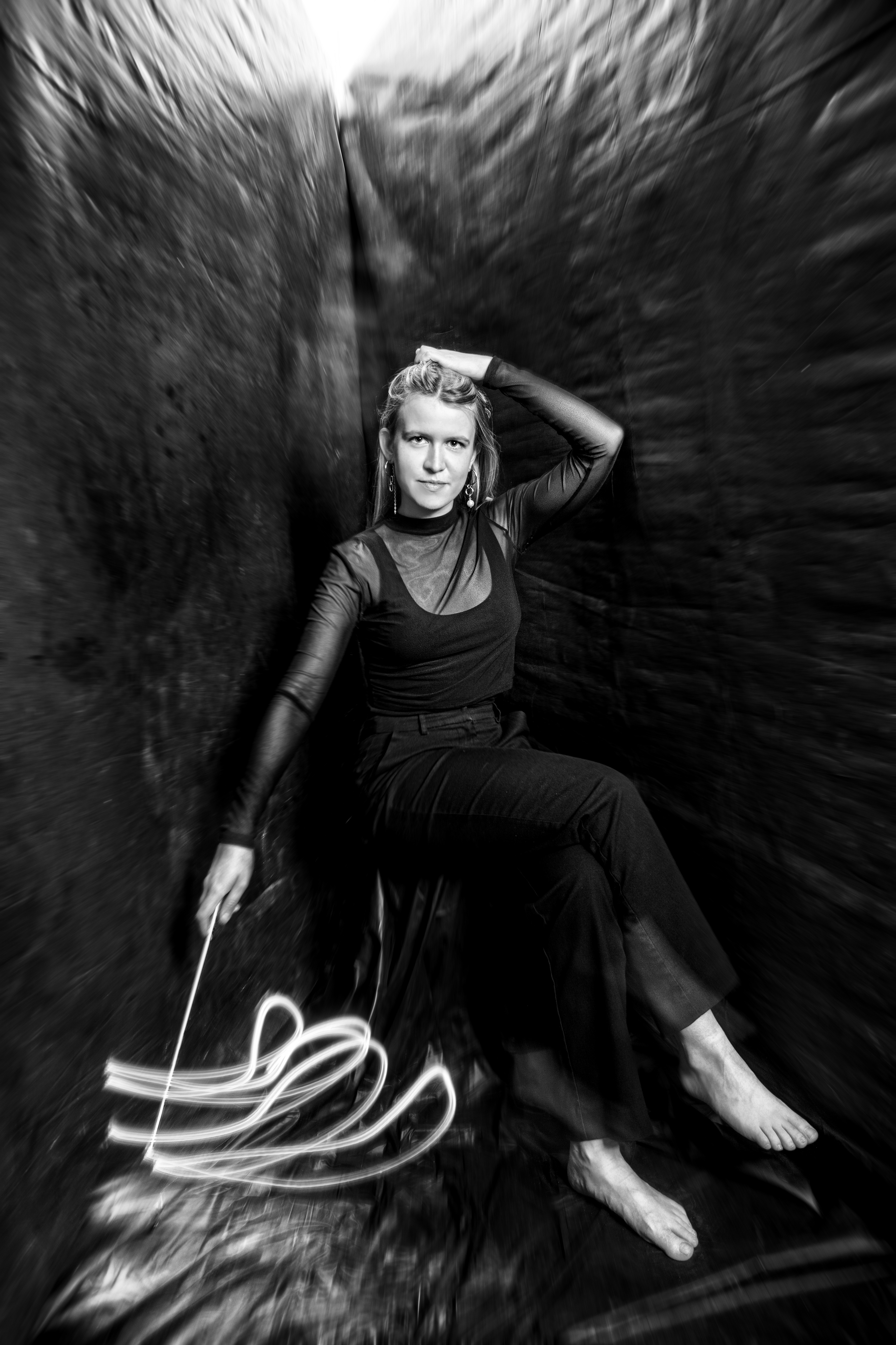 Ragnheiður Ingunn Jóhannsdóttir iklædt sort med sin dirigentstang i højre hånd, der peger nedad og ligner en tryllestav. 