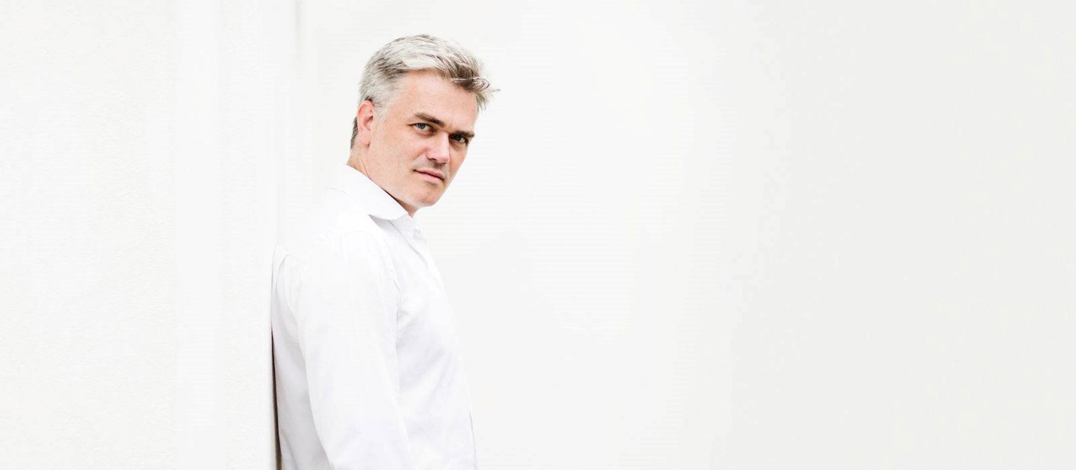 Edward Gardner iført hvid skjorte foran hvid baggrund