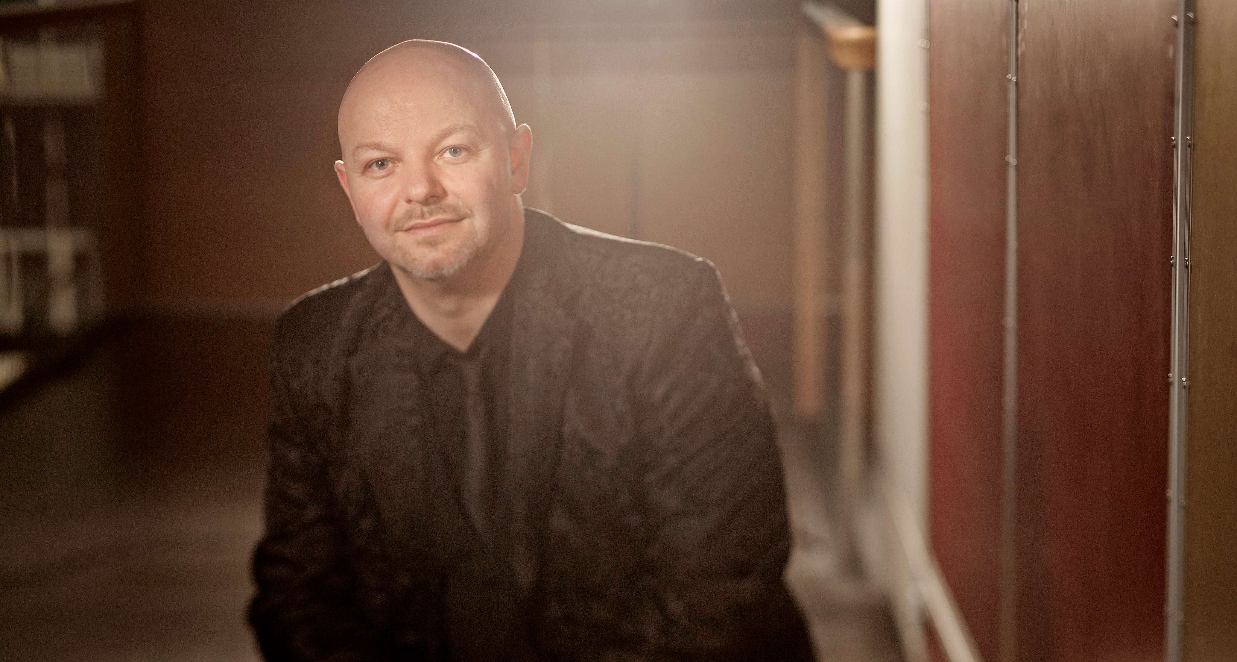 Skaldede Henrik Gunde i helt sort jakkesæt 