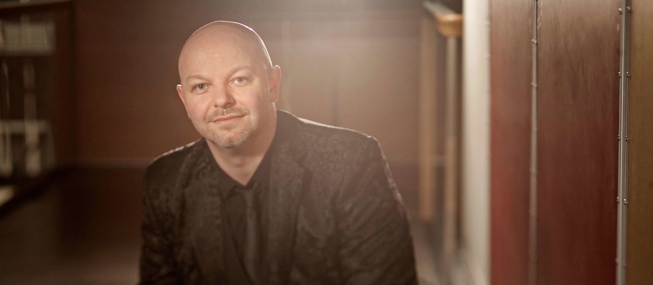 Skaldede Henrik Gunde i helt sort jakkesæt