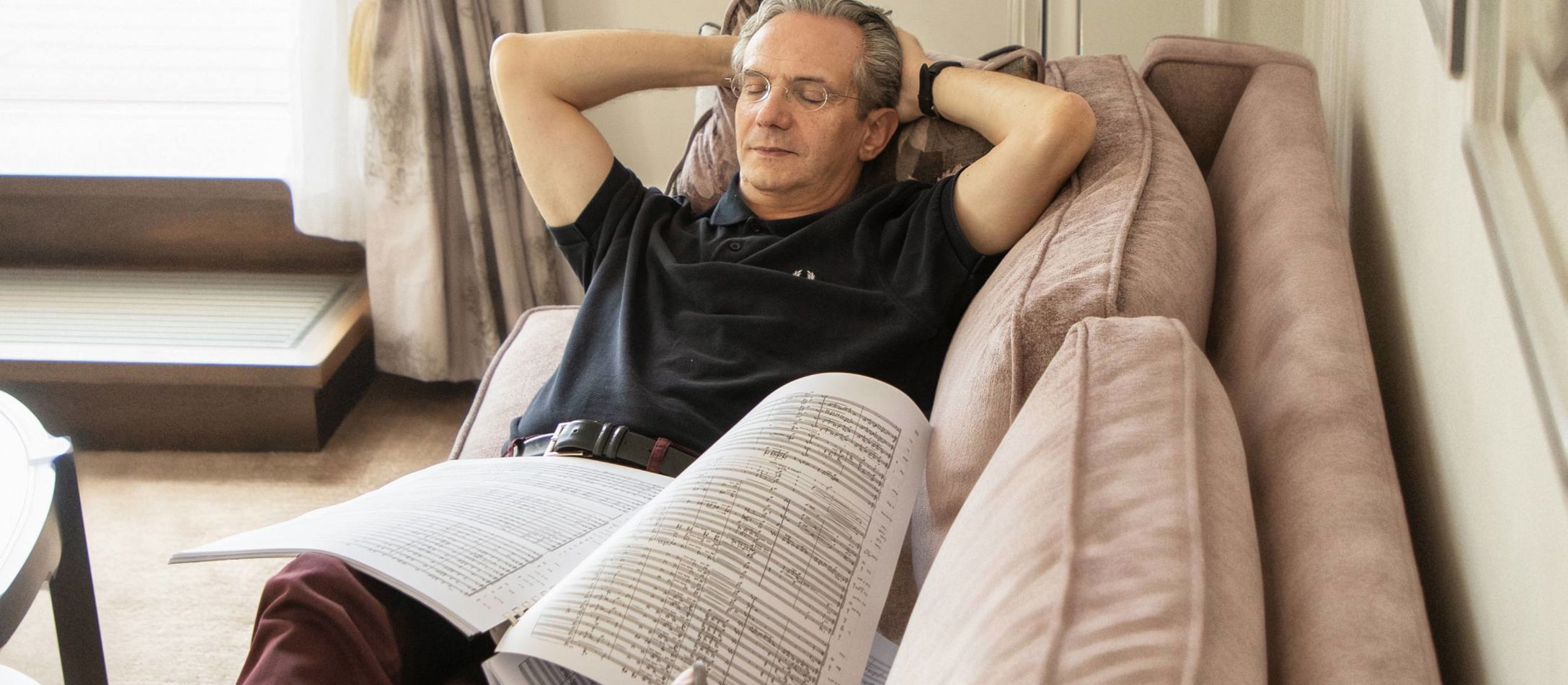 Dirigent Fabio Luisi ligger i en sofa og læser noder