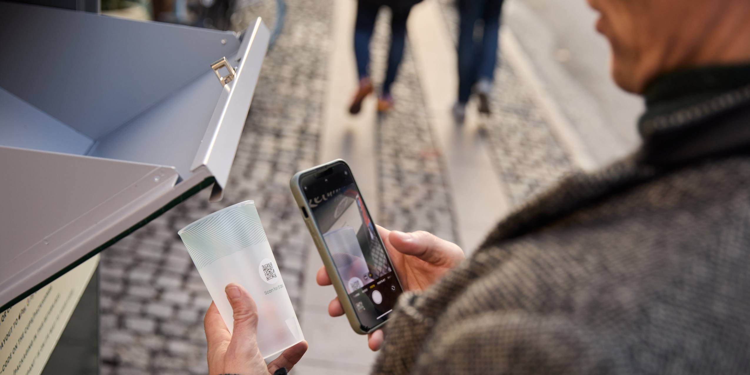 En person der scanner en pantkop fra New Loop for at returnere den