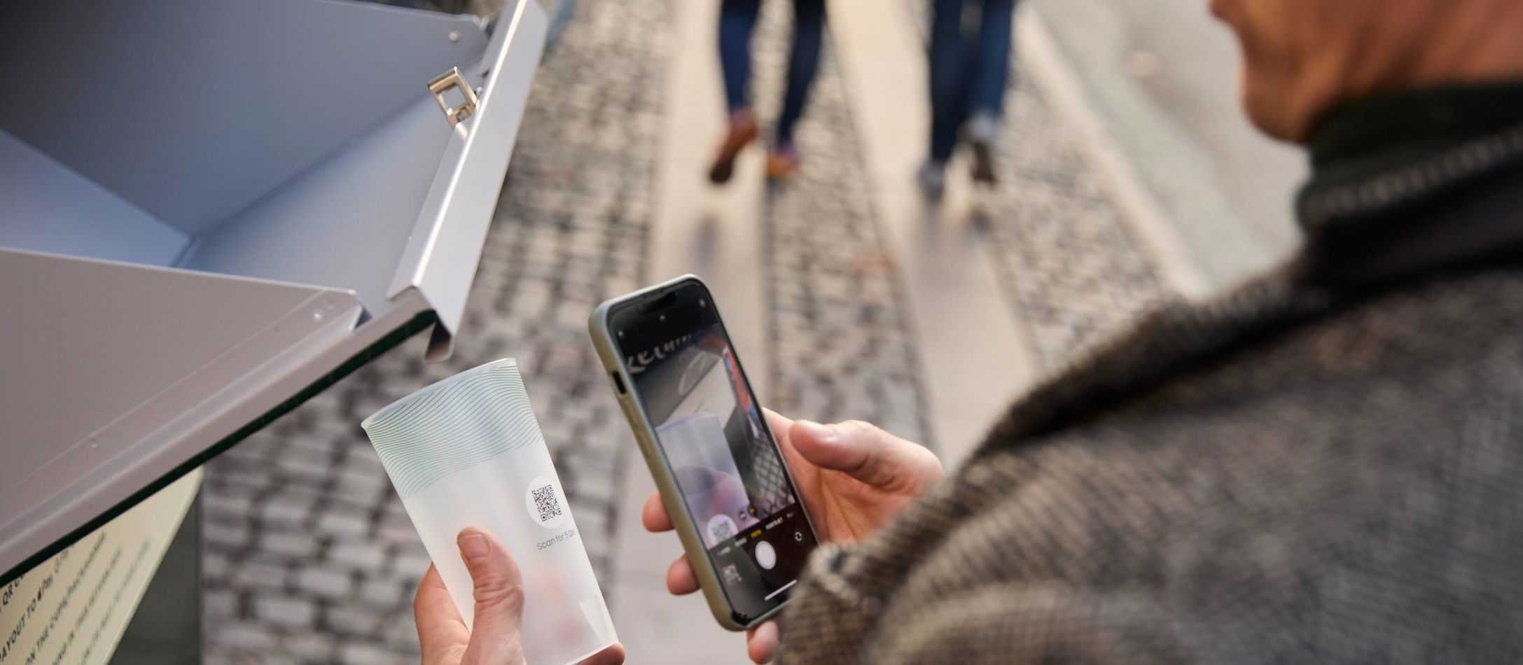 En person der scanner en pantkop fra New Loop for at returnere den