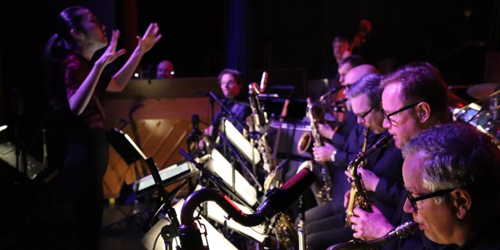 Miho Hazama i færd med at dirigere DR Big Band, der spiller på blæseinstrumenter.