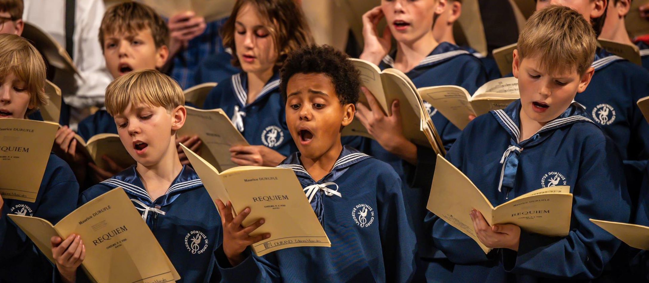 Københavns Drengekor iført sejleruniform synger med sanghæfter i hænderne
