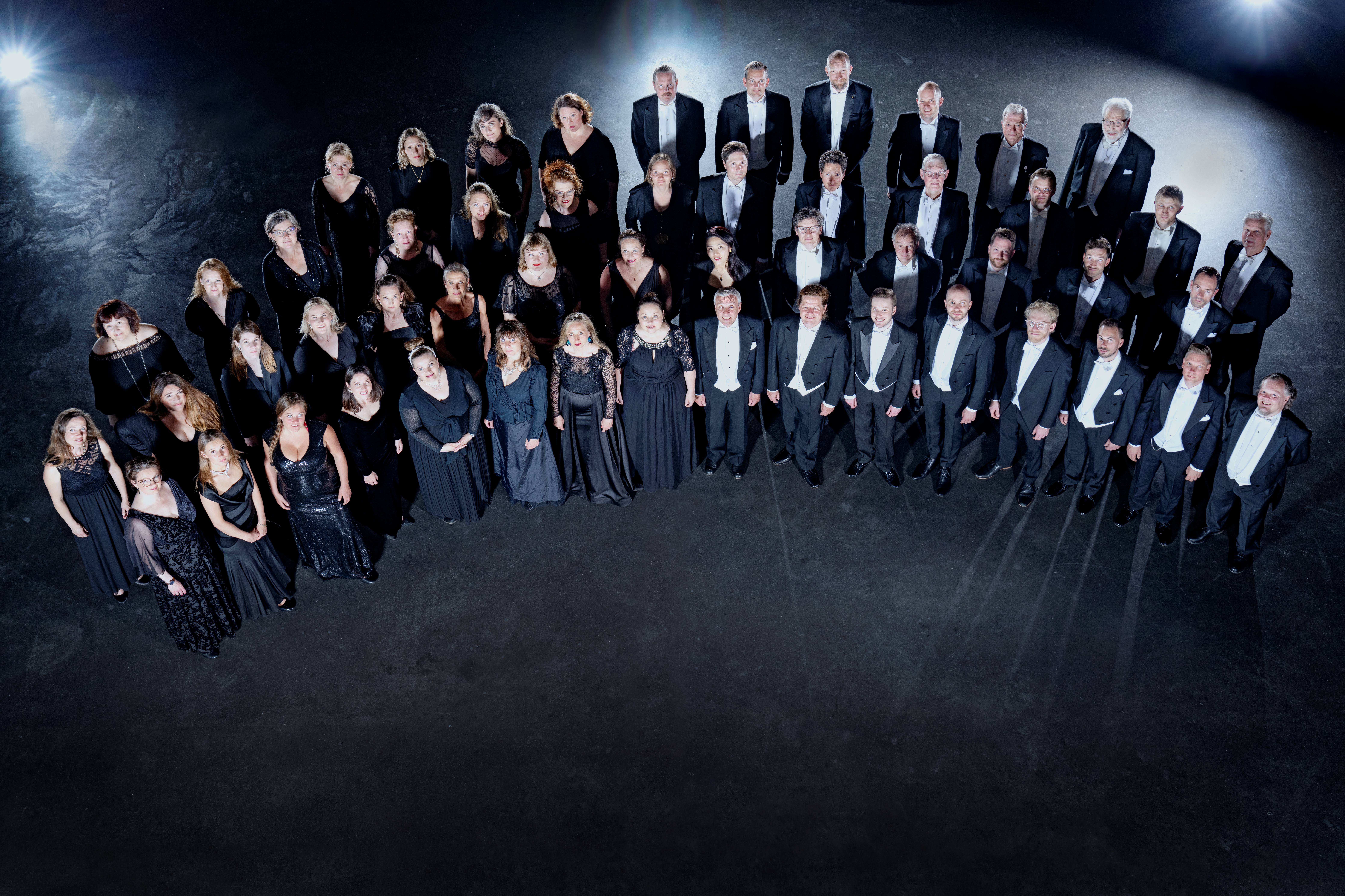 DR Koncertkoret iført formelt tøj foran sort baggrund