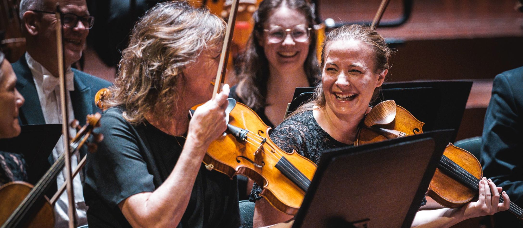 Musikere i DR Symfoniorkestret griner og smiler til hinanden