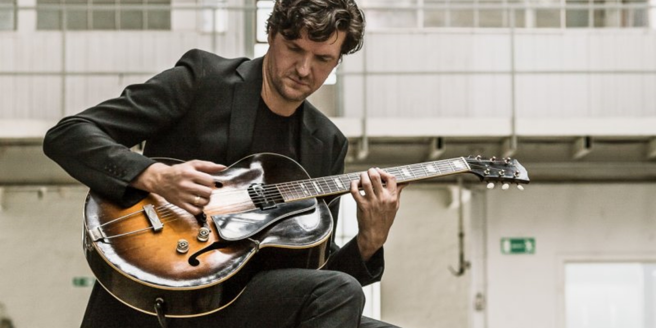 Mads Kjølby i gang med at spille guitar