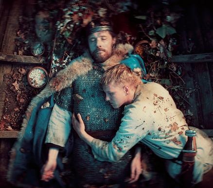 Afdød vikingekonge i bunden af båd bliver krammet af sørgende ung viking. 