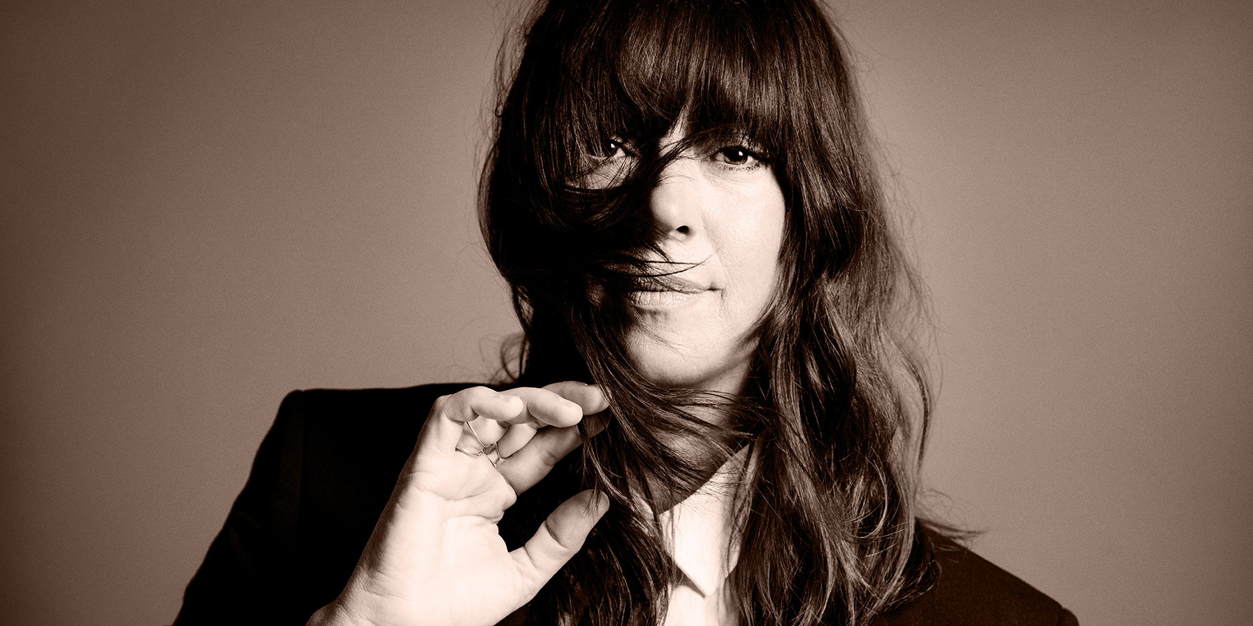 Cat Power med vindblæst mørkt hår og intense mørke øjne.