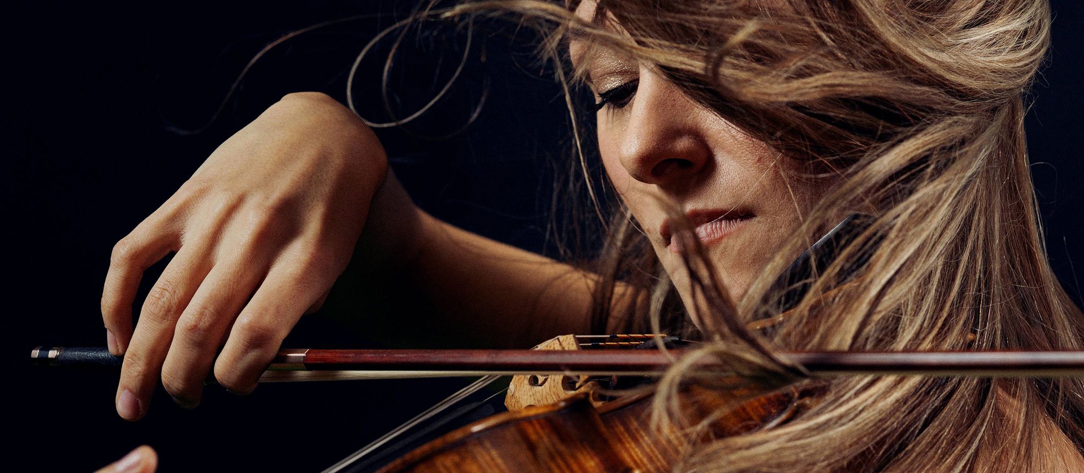 Anna Agafia Egholm med flagrende hår mens hun spiller violin